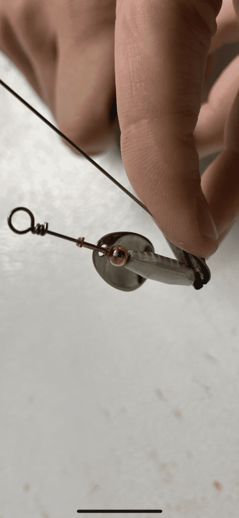 The last step in creating a spinner bait is to add a treble and close the wire loop.